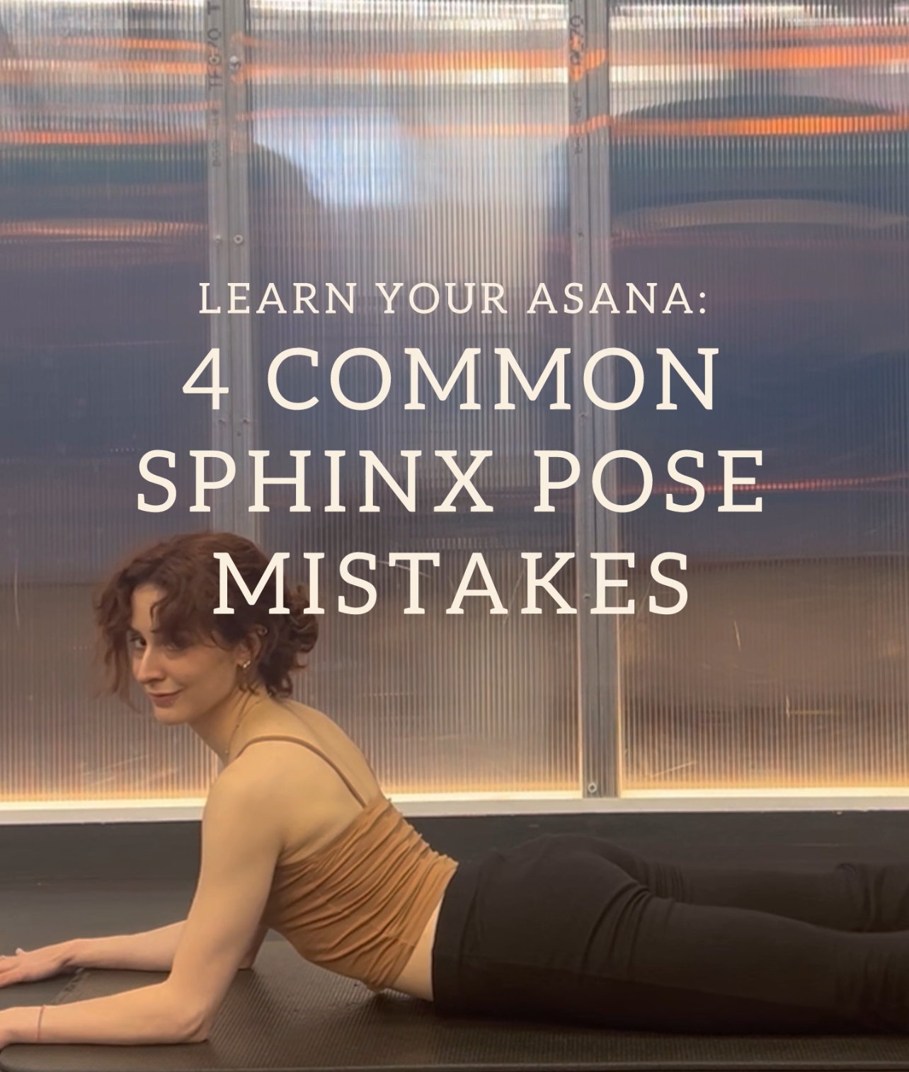 A woman in sphinx pose on yoga mat.