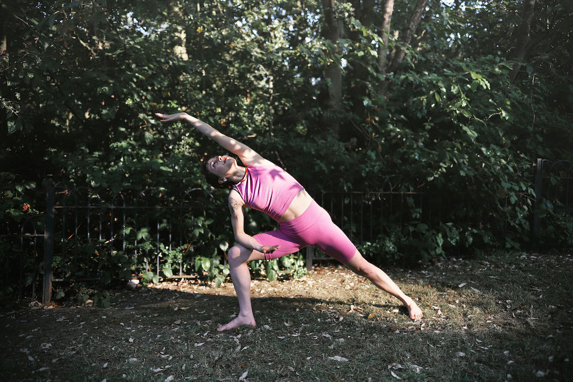 Necla doing a reverse warrior yoga pose at the park